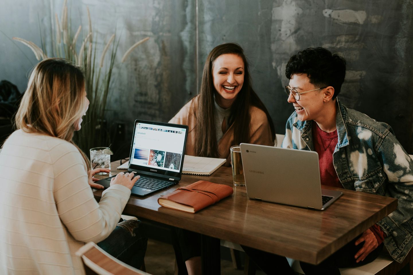 A group of people at a table working on laptops
